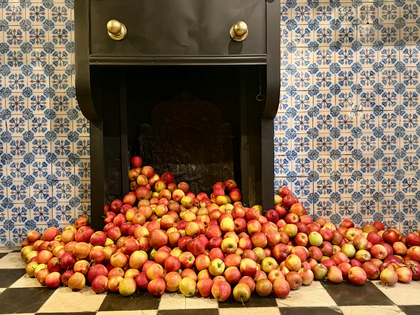 Red apples spilling onto a chequered floor