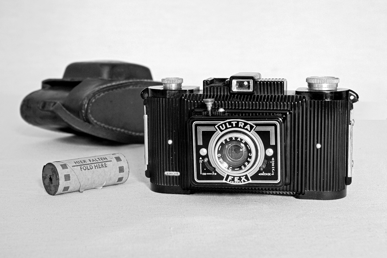 Vintage folding camera with a film roll and a leather case